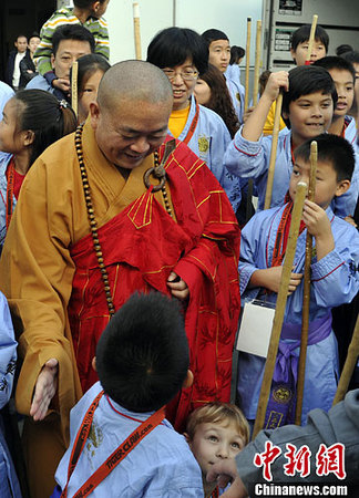 圖為少林寺釋永信方丈與參加武術(shù)交流的兒童們交談。中新社發(fā) 毛建軍 攝