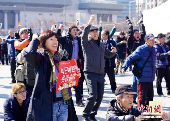 3月10日，在象征著韓國政治中心的首爾光化門廣場，民眾在聽到憲法法院對總統(tǒng)樸槿惠彈劾案的審判結(jié)果后歡呼。韓國憲法法院當(dāng)日作出裁決，宣布彈劾案成立。樸槿惠成為韓國歷史上首位被彈劾罷免的總統(tǒng)。<a target='_blank' href='http://www.chinanews.com/'>中新社</a>記者 吳旭 攝