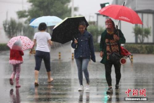 資料圖：民眾在雨中出行。