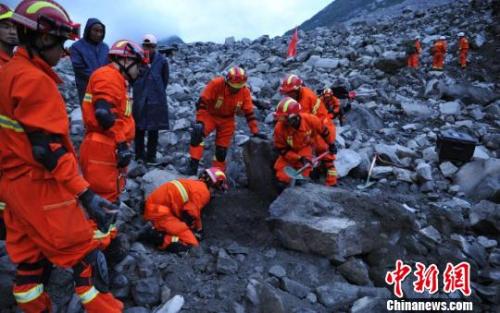  救援人員在挖掘遇難者遺體。　劉忠俊 攝