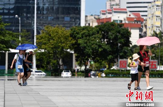 7月13日，廈門市民行走在熱浪滾滾的路面上。　張斌 攝