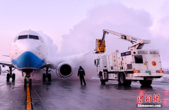 資料圖：機務(wù)人員用器械給飛機除冰。賀晟 攝