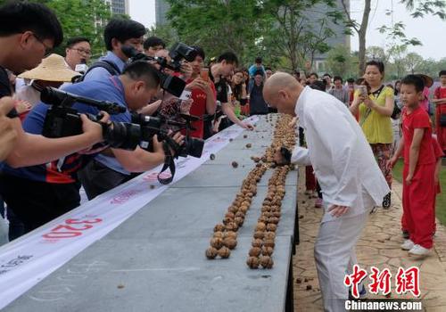 黎偉軍手劈核桃現(xiàn)場(chǎng)吸引不少人圍觀。　程景偉 攝