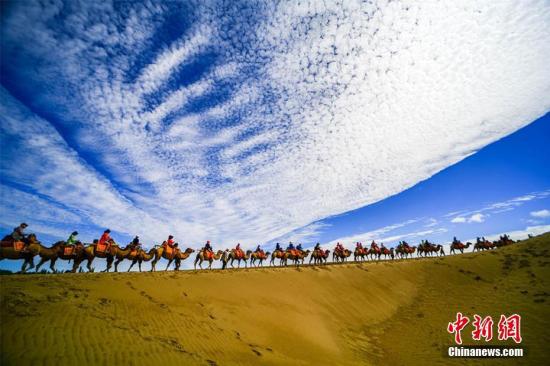 資料圖：甘肅敦煌鳴沙山月牙泉景區(qū)藍(lán)天、白云、黃沙相映成趣，每天吸引數(shù)萬中外游客觀光游覽。 王斌銀 攝