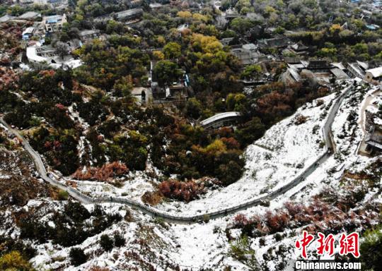 11月4日早晨，航拍視角中的蘭州城區(qū)一角，繽紛秋色中點(diǎn)綴著點(diǎn)點(diǎn)白雪?！钇G敏 攝