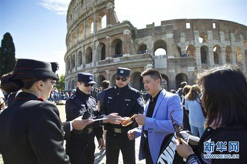 這是2016年5月2日，在意大利羅馬斗獸場外，中方警員在核查一個中國旅游團的證件。當(dāng)日，首次中意警務(wù)聯(lián)合巡邏在意大利羅馬啟動。新華社記者金宇攝