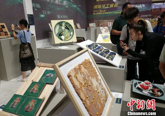 市民正在觀看展出的手工瓷磚設(shè)計(jì)作品。　程景偉 攝